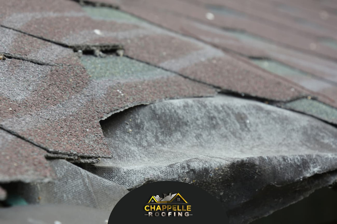 A damaged roof with shingles on it requiring immediate attention for roofing problems.