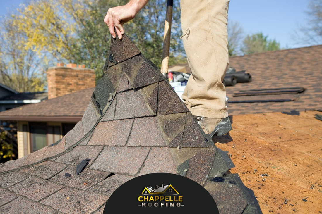 A man replacing an aging roof on a house, navigating hazards for a safe roof replacement.