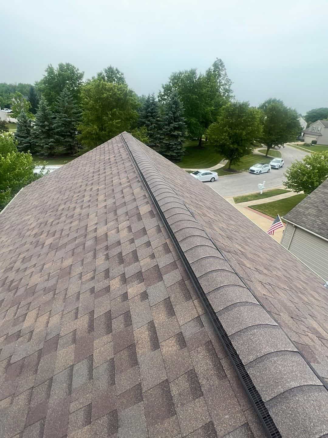 Aerial view of a shingled roof undergoing work.