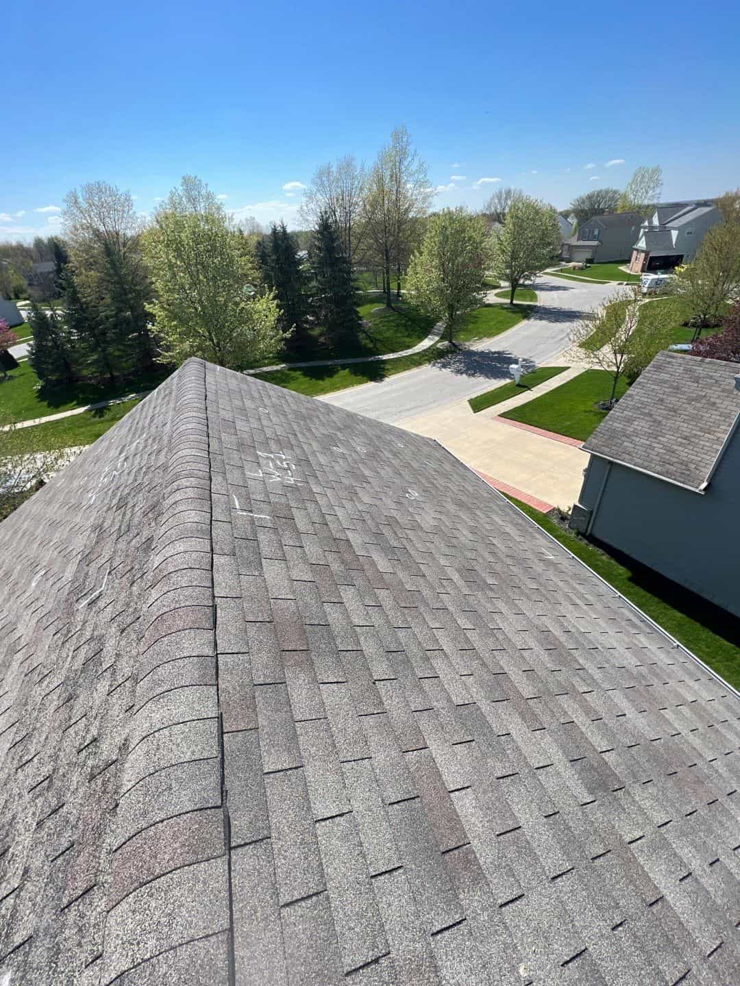 An important aerial view of a shingled roof in a residential neighborhood.