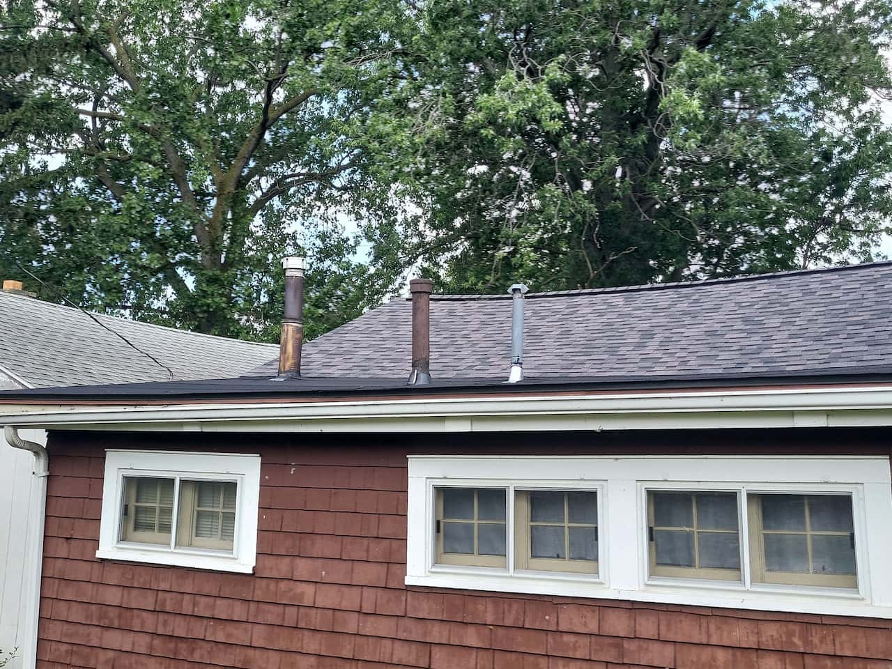 A house with a brown roof and two chimneys provides a beautiful backdrop for work or relaxation.