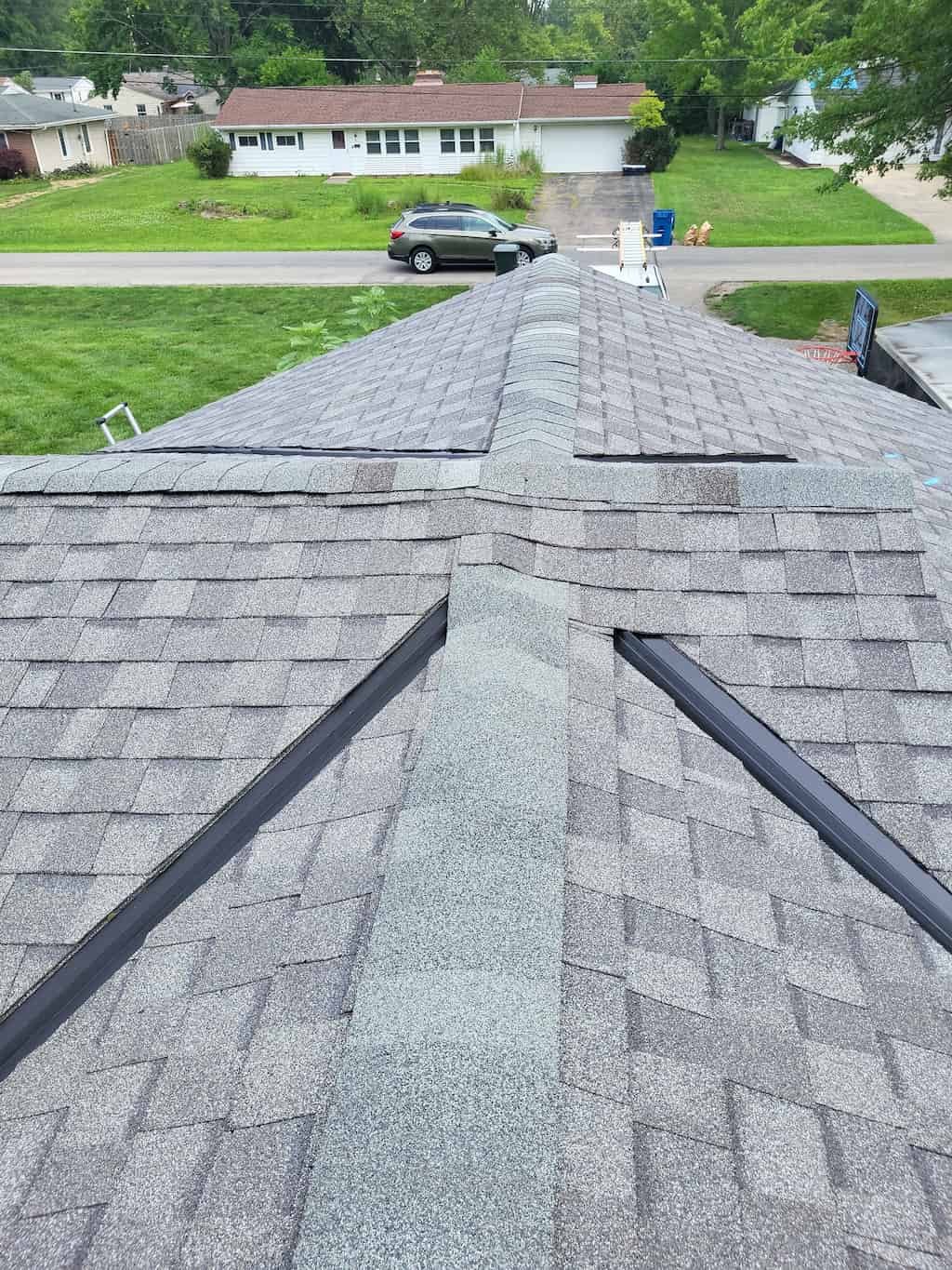 An aerial view of a shingled roof showcasing the meticulous workmanship and precision involved in its construction.