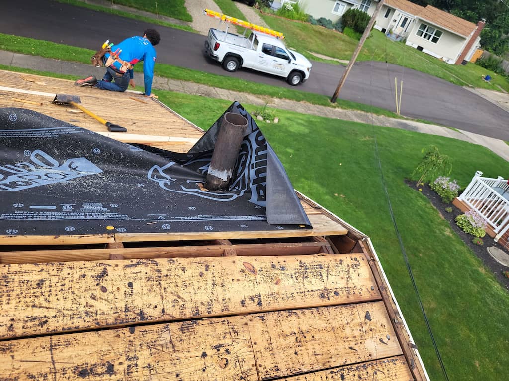 A man is working on emergency roof repair of a house.