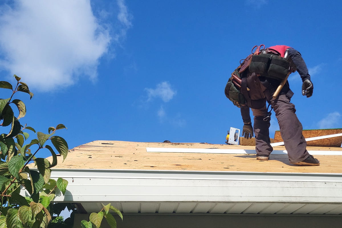 A man performing metal roof installation on a house in Ohio.