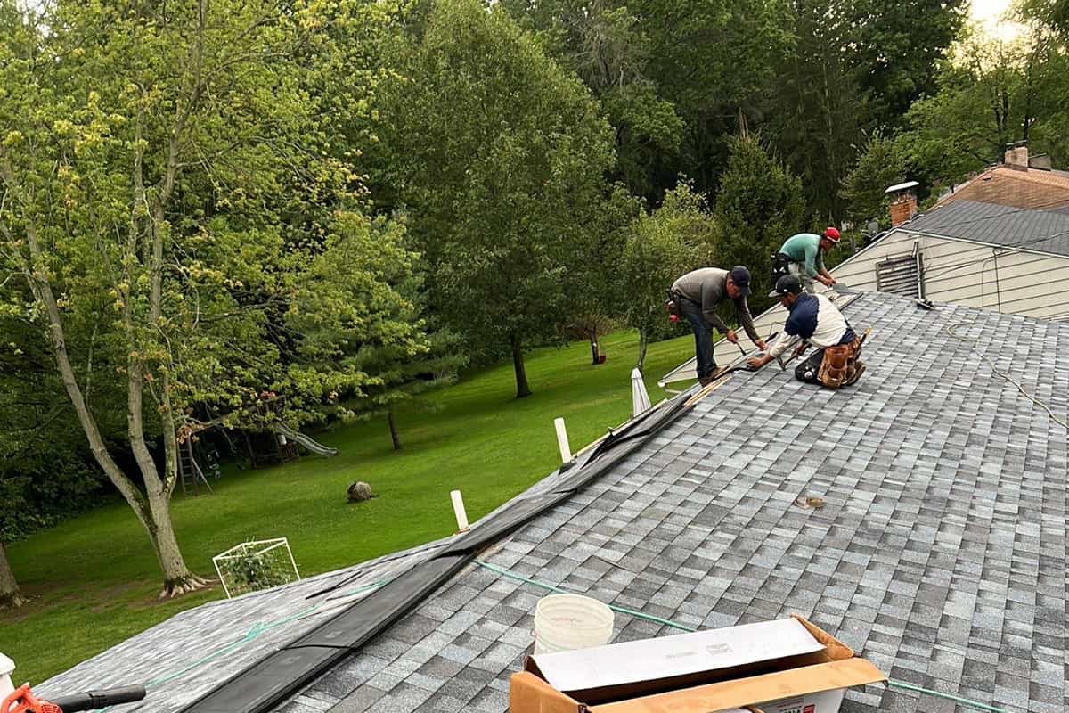 A group of men performing a roof replacement.