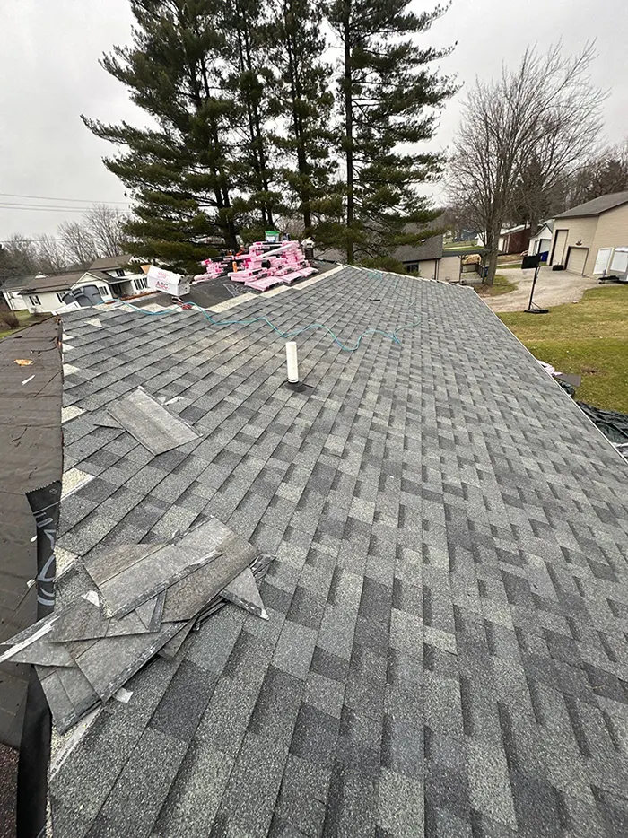 A shingled roof is being installed on a house, which is an important aspect for proper home maintenance work.
